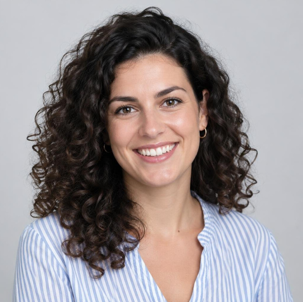 Studio portrait of a young woman with curly hair smiling